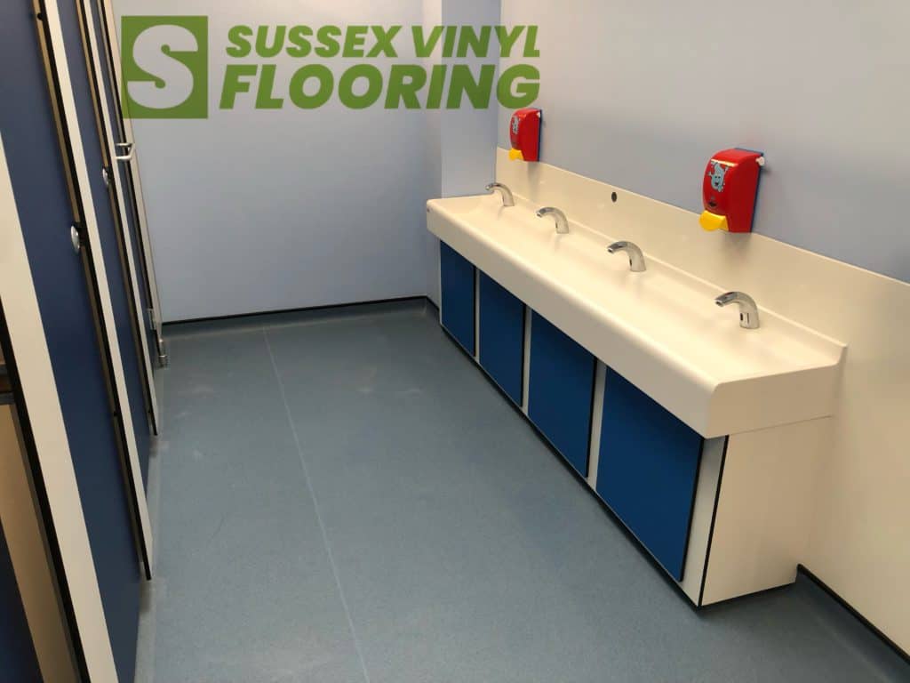 Blue safety flooring by Altro laid to toilets in Hailsham.